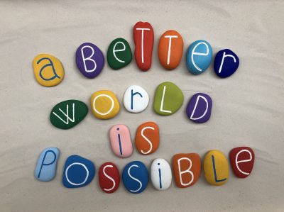 a-better-world-is-possible-social-issue-slogan-with-handmade-multi-colored-stone-letters-over-white_t20_rRQyEz