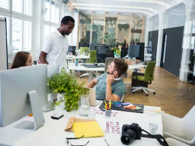 Graphic Designers Interacting At Their Desk