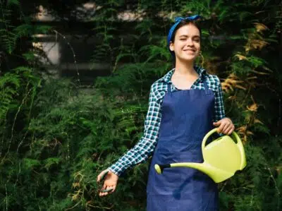 Smiling Woman With Watering Can Pruning Plant With Secateurs 23 2147918794